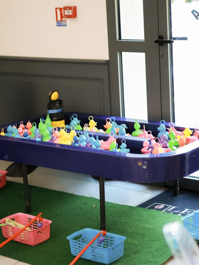 Bassin de pêche aux canards colorés avec cannes et petits paniers