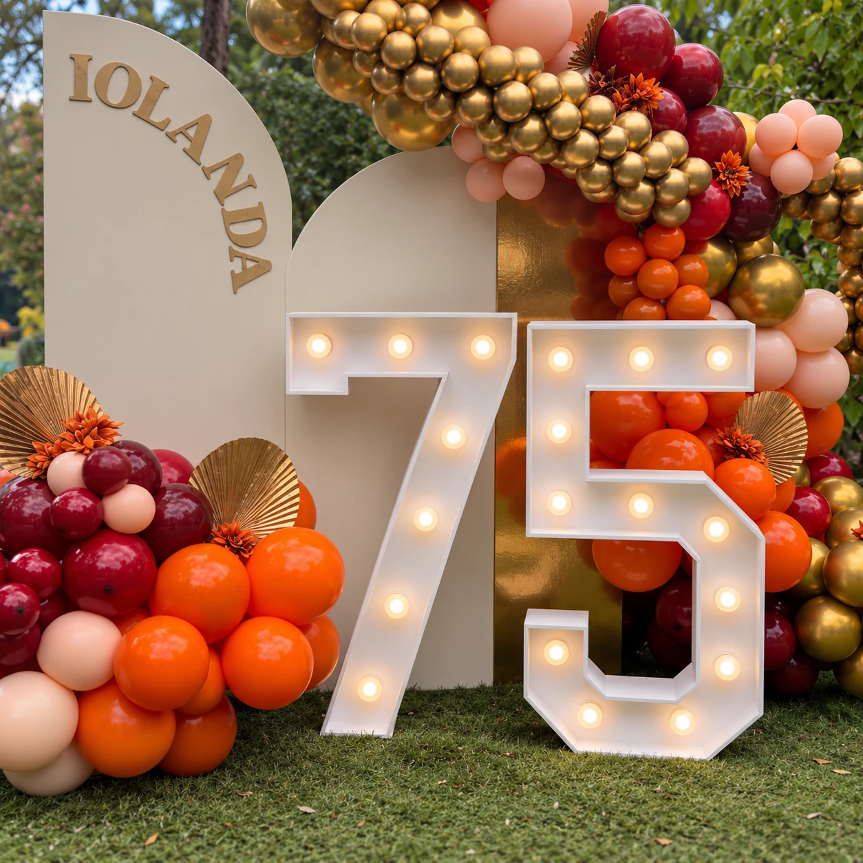 Gros plan sur les chiffres 75 allumés devant le décor d’anniversaire d’Iolanda