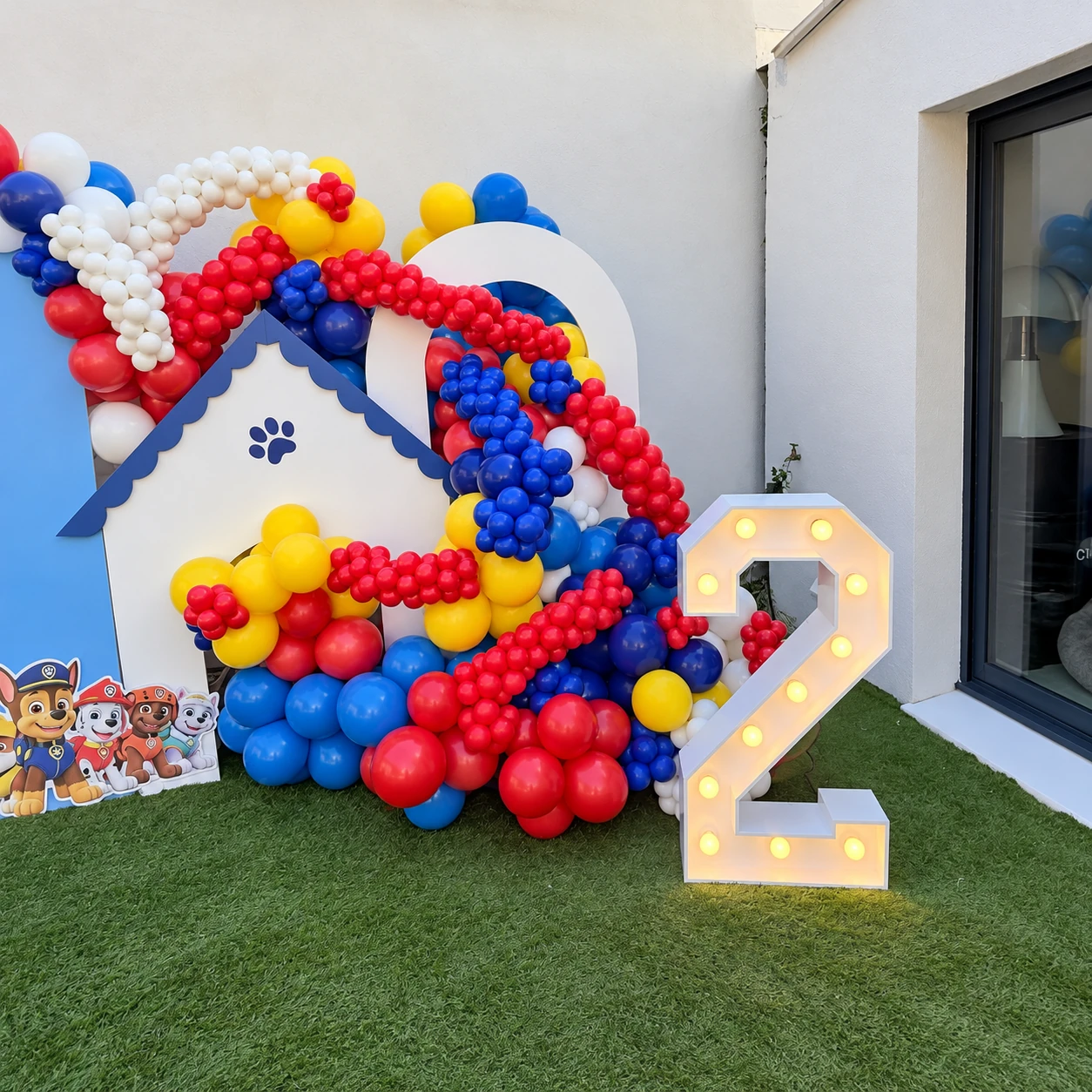 Chiffre 2 lumineux et structure maison entourée de ballons colorés