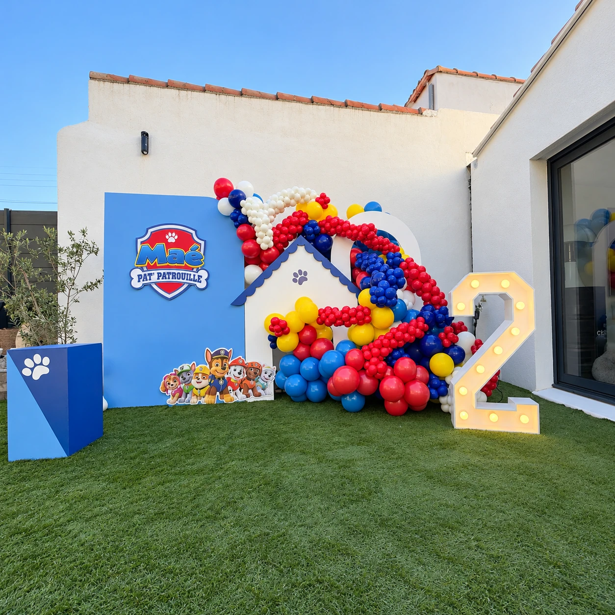 Vue complète du décor Pat’Patrouille de Maé avec ballons rouges, jaunes et bleus et chiffre 2 éclairé