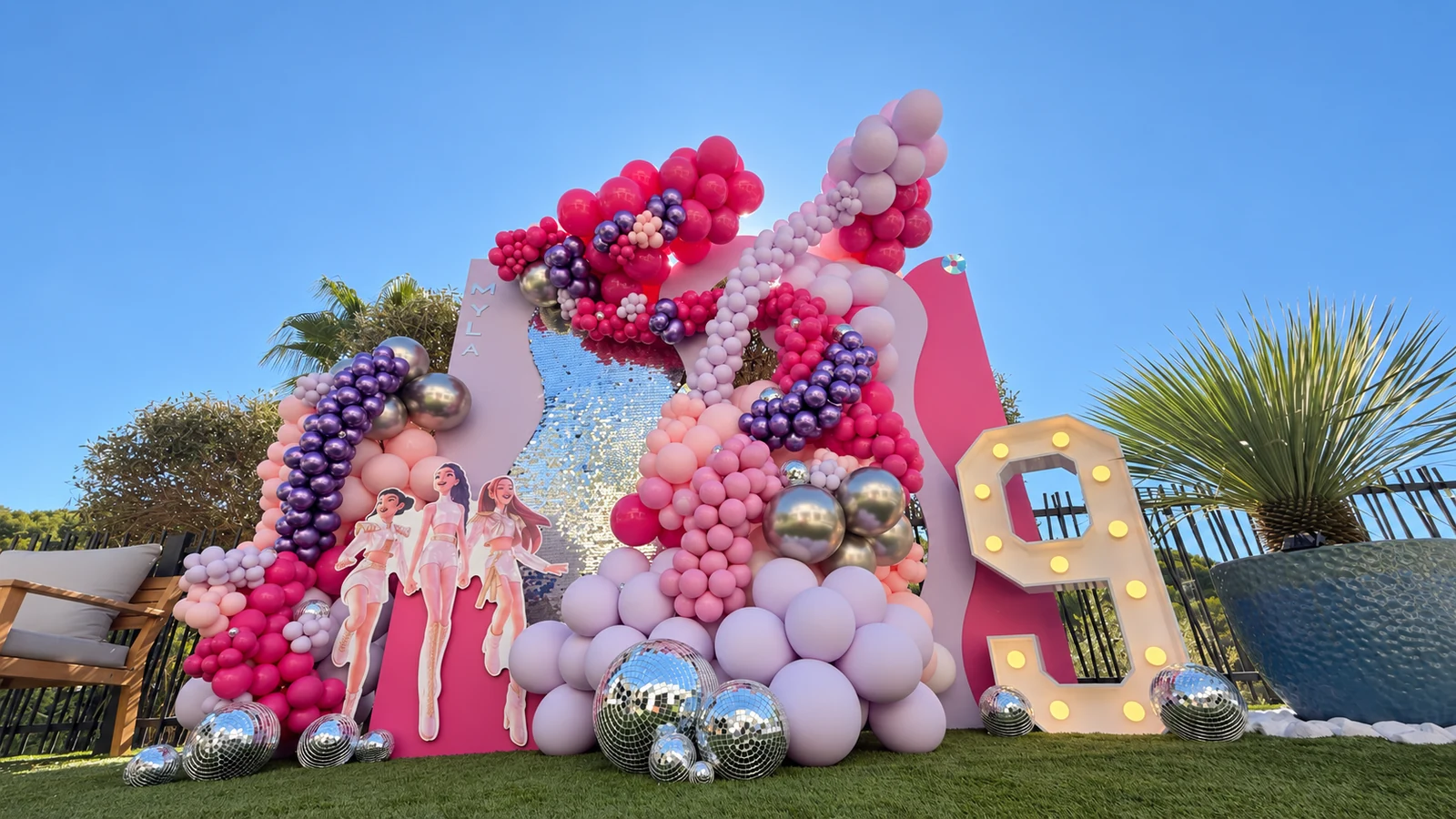 Décor d’anniversaire K-pop de Myla avec ballons roses et violets, fond scintillant et chiffre 9 lumineux