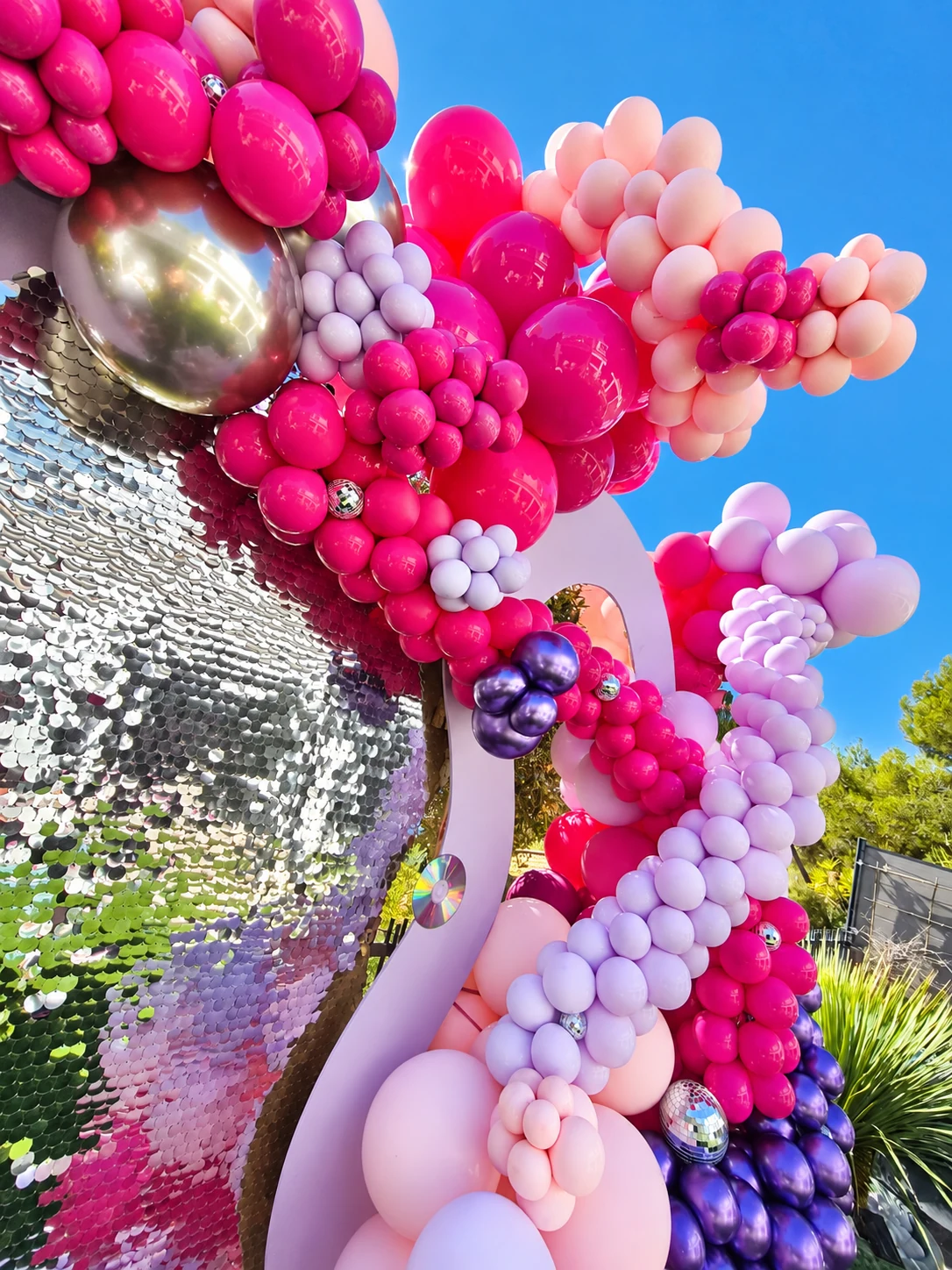 Détail des ballons rose fuchsia, rose poudré et lilas autour du fond argenté