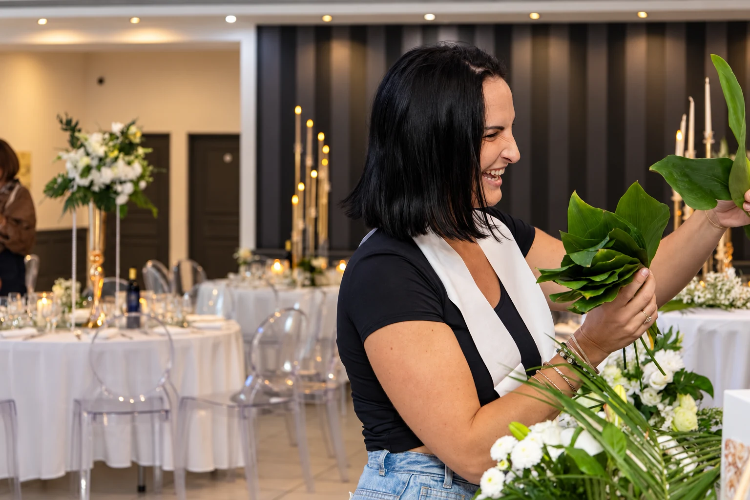 Charlène sourit pendant la préparation des fleurs pour les 60 ans de sa maman Nicole