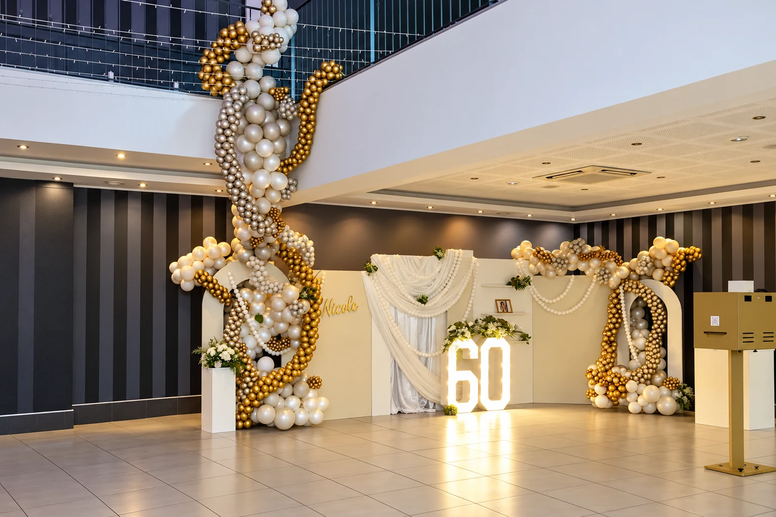 Décor complet des 60 ans de Nicole avec drapés blancs, perles, cascade de ballons et chiffres lumineux