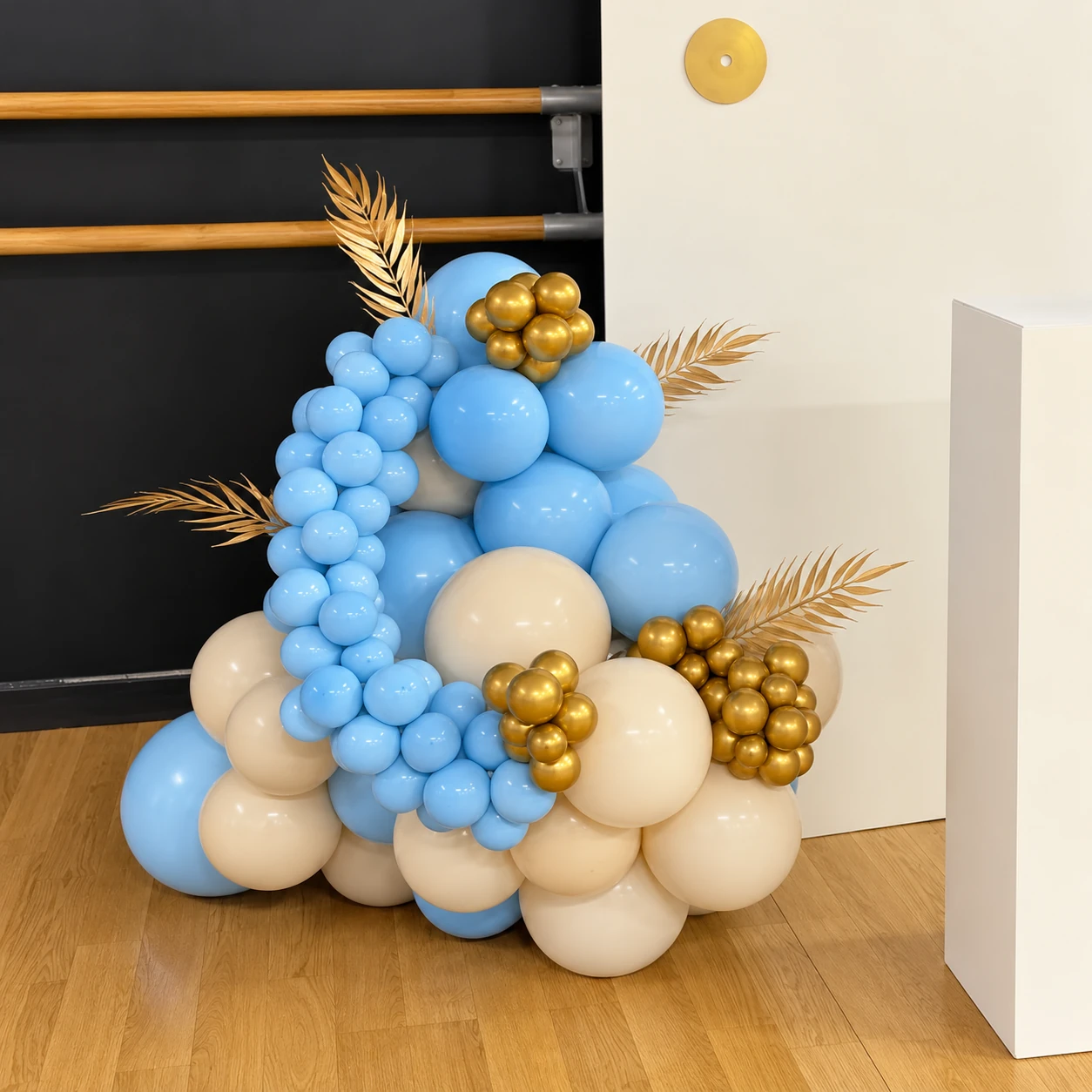 Ballons bleu pastel, crème et dorés au pied du panneau musical