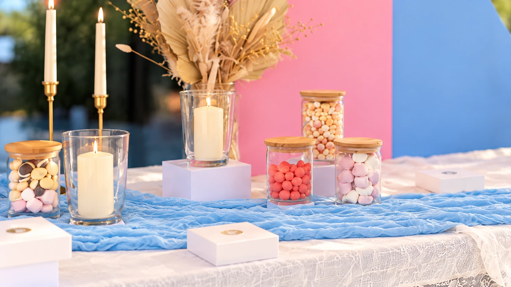 Pots de douceurs, bougies et détails pastel sur la table en dentelle