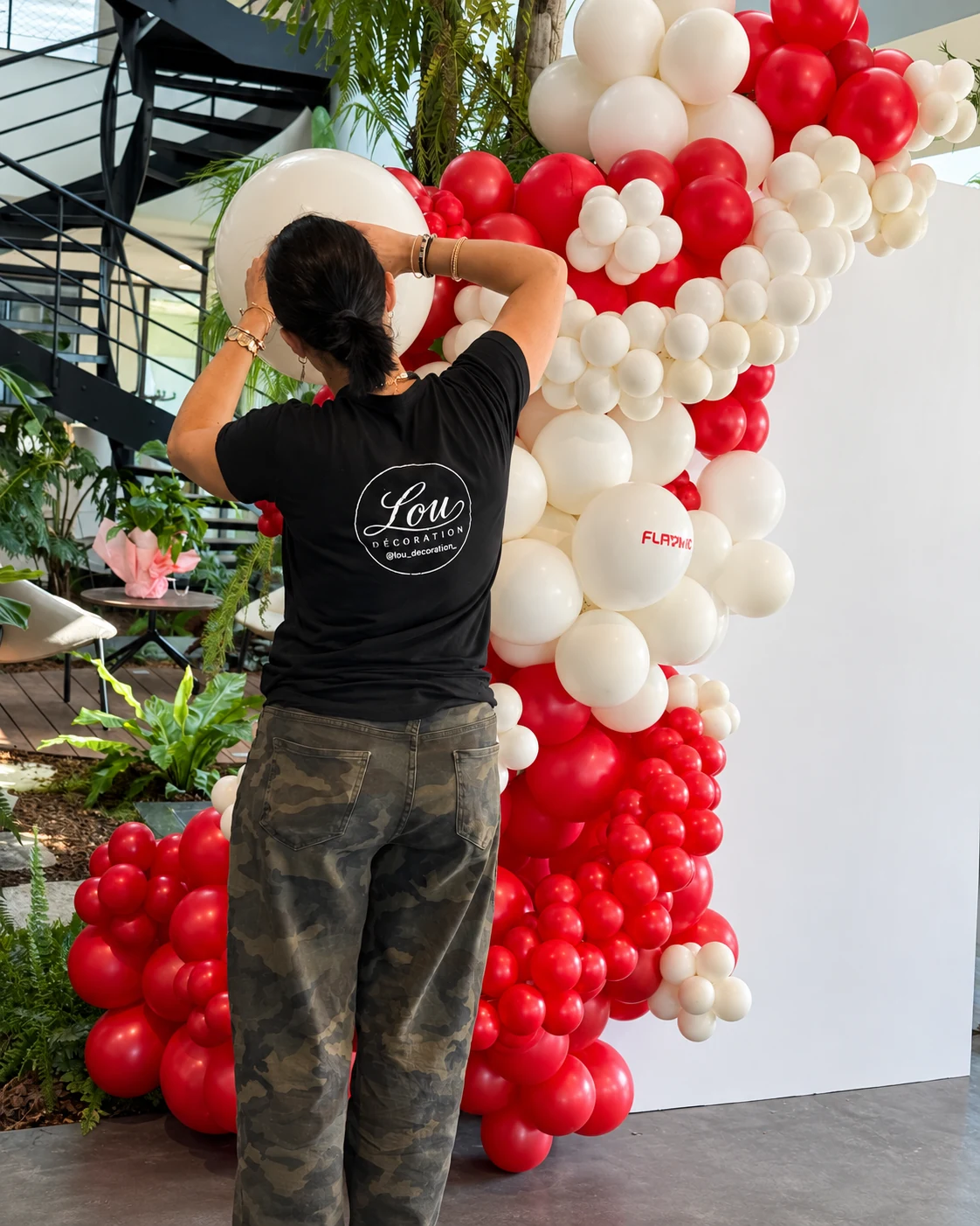 Charlène finalise le panneau blanc pendant l’installation du décor Flavine rouge et blanc