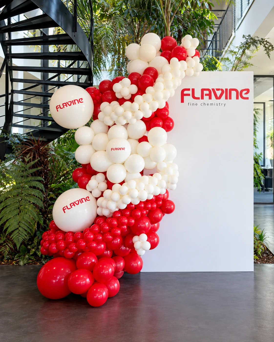 Décor Flavine à Marignane avec panneau au logo rouge et ballons rouges et blancs en composition organique