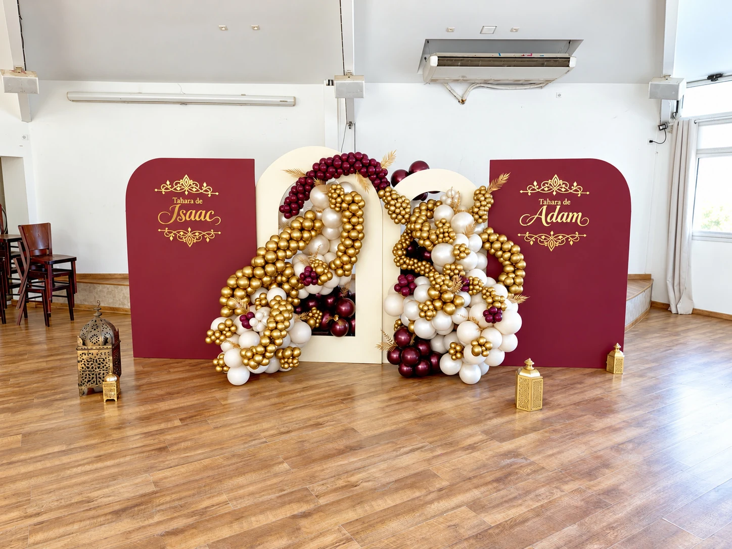 Décoration de la Tahara d’Isaac et Adam avec panneaux bordeaux, arches ivoire et ballons dorés